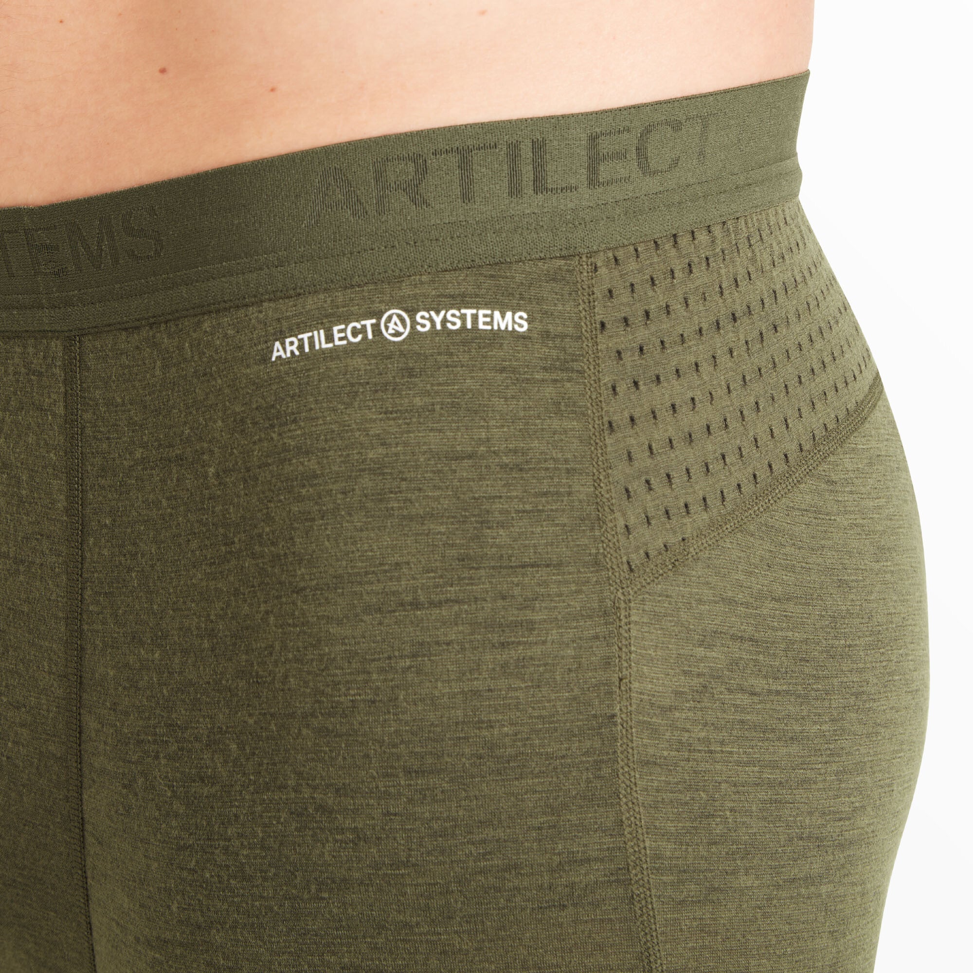 A detailed close-up of the upper side of the Artilect Performance Mens Boulder 125 Legging Green, highlighting the soft waistband with raised “ARTILECT SYSTEMS” branding. The image also shows the perforated ventilation panel integrated into the hip area and the fine knit texture of the fabric.