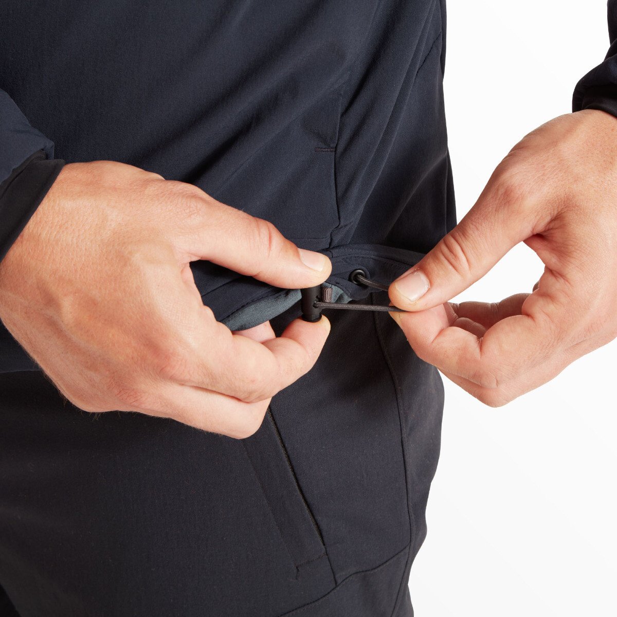 Close-up of the hem adjustment cord being pulled by the model’s hands, demonstrating the adjustable fit feature for better insulation and custom comfort on the Artilect Performance Mens Elevate Primaloft Bio Insulated Hoodie Blue.