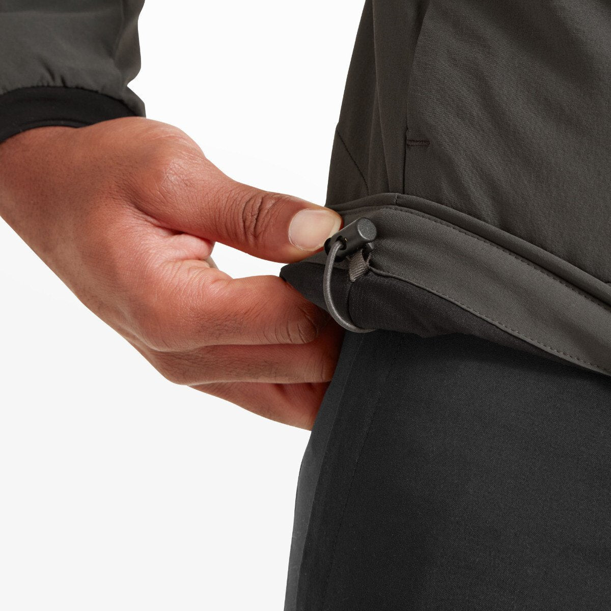 The man is shown tightening the hem using the built-in drawcord adjustment feature, demonstrating fit customization and detail stitching on the Artilect Performance Mens Elevate Primaloft Bio Insulated Hoodie Grey.