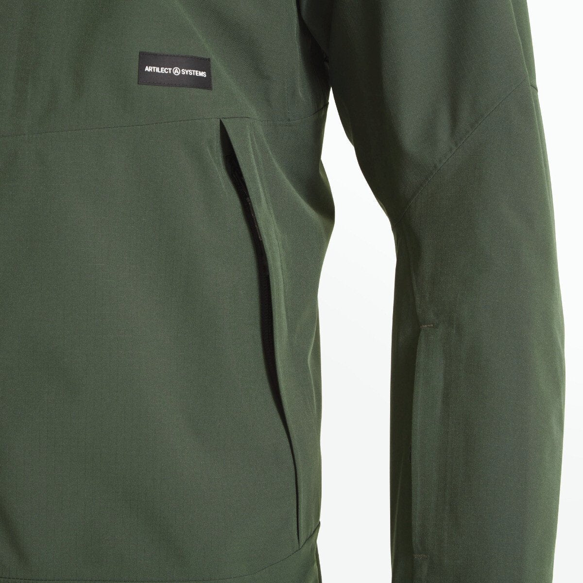 Zoomed-in view of the left chest and pocket area on the Artilect Performance Mens Grandview 3L Jacket Green. A vertical zipper pocket is visible, and the Artilect Systems logo patch is shown above the pocket seam.