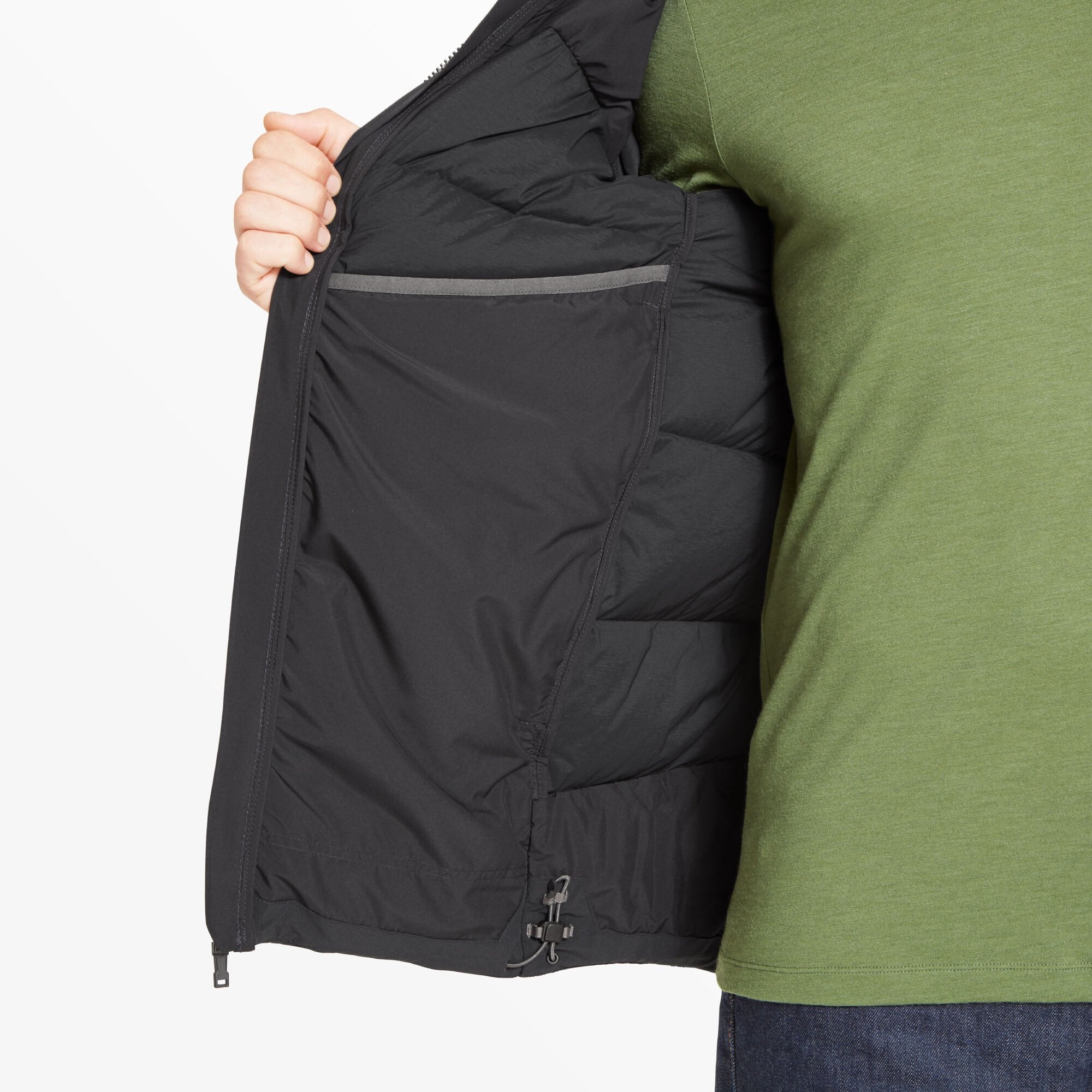 A partial view of the Artilect Performance Mens High AF Down Stretch Parka Black opened by the model to show the inside left chest pocket and internal insulation layers. The lining is smooth and has a subtle sheen.