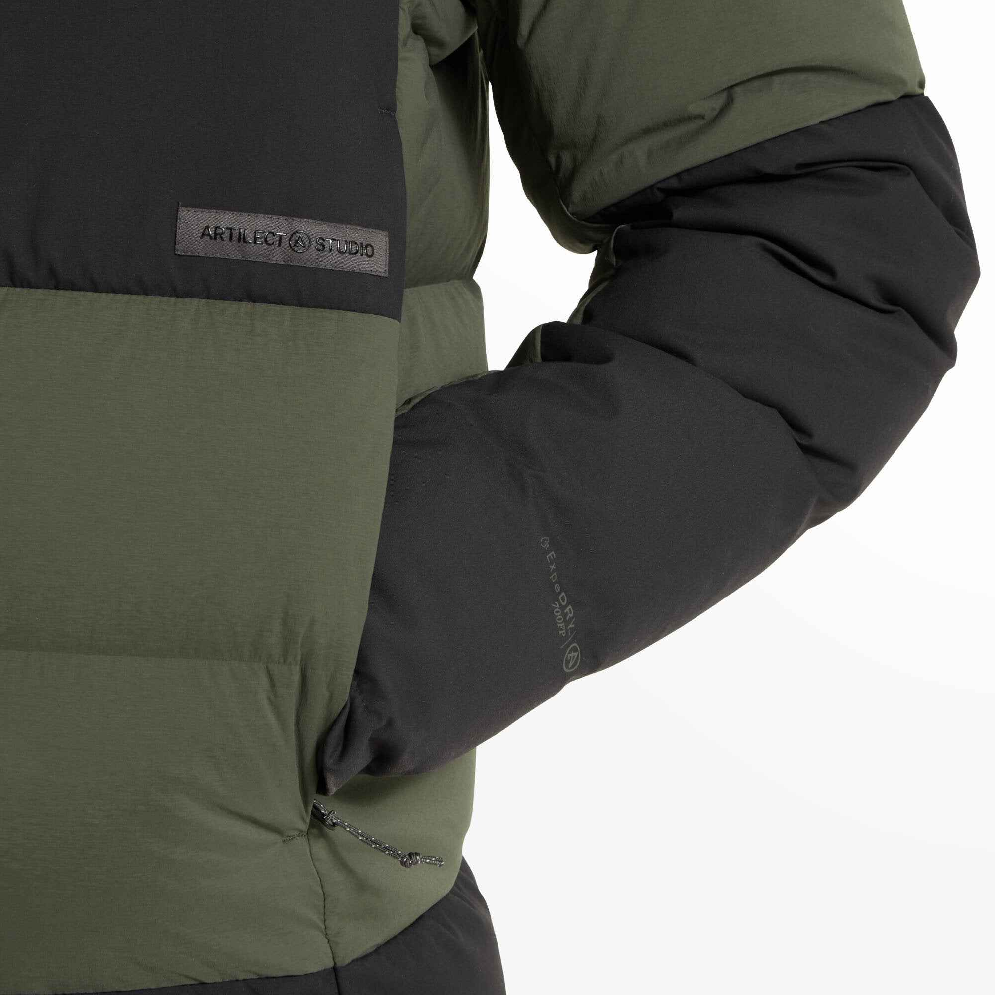 Close-up of the Artilect Performance Mens High AF Down Stretch Parka Green’s midsection showing the zippered hand pocket and a stitched rectangular black patch reading "ARTILECT STUDIO" in gray. The pocket zippers and insulation thickness are emphasized, highlighting warmth and storage features.