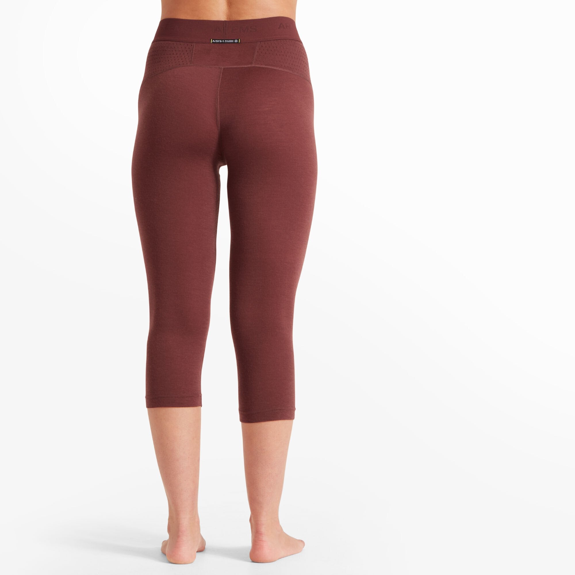 A back view of the Artilect Performance Womens Boulder 125 3/4 Legging Burgundy. The waistband features a small logo patch at the center, and the perforated detailing at the back is clearly visible. The leggings fit snugly around the hips and thighs and taper down just below the knees.