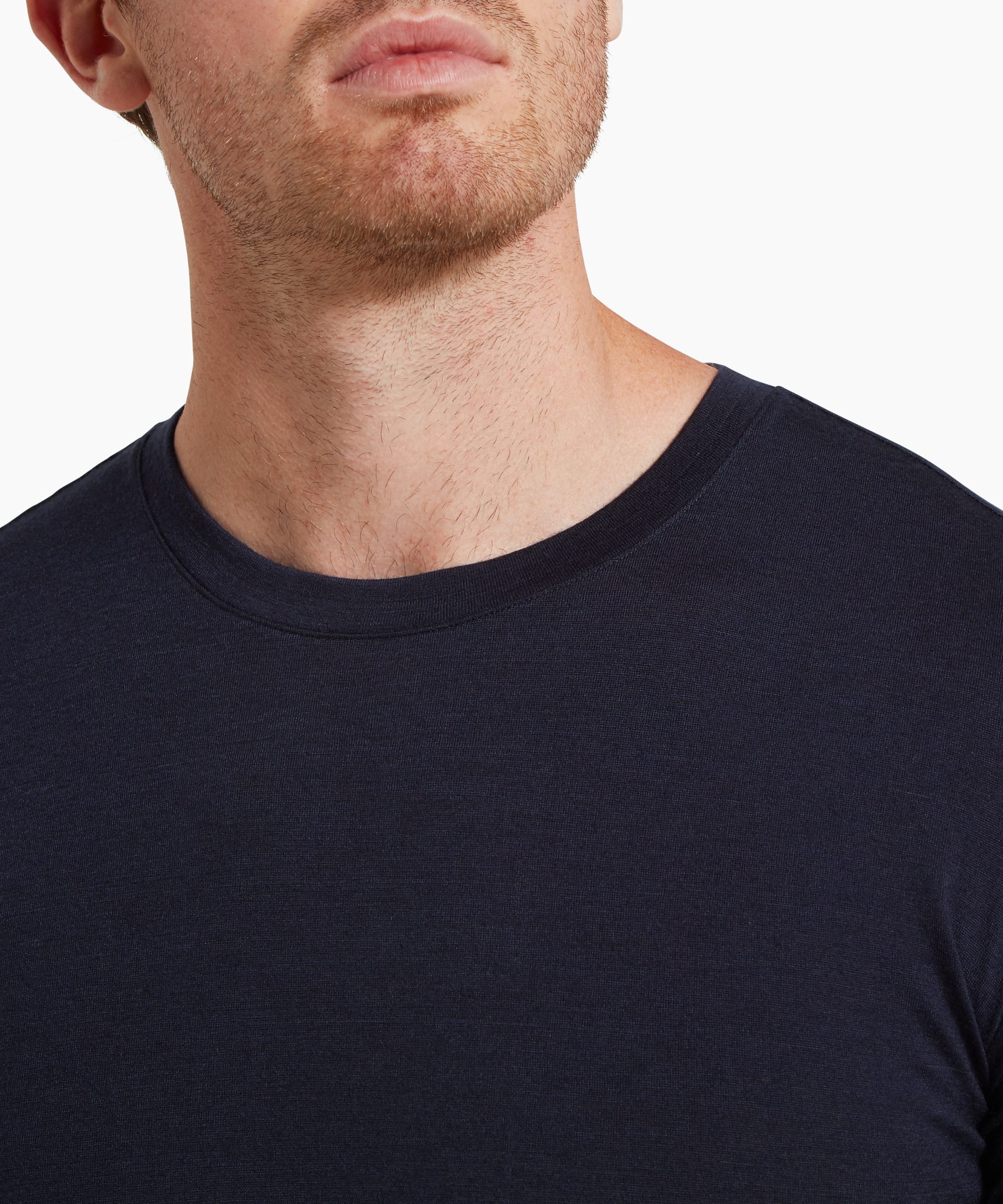 A close-up of the upper chest and neckline of a navy short-sleeve T-shirt, showing fabric texture and the crew neck seam.