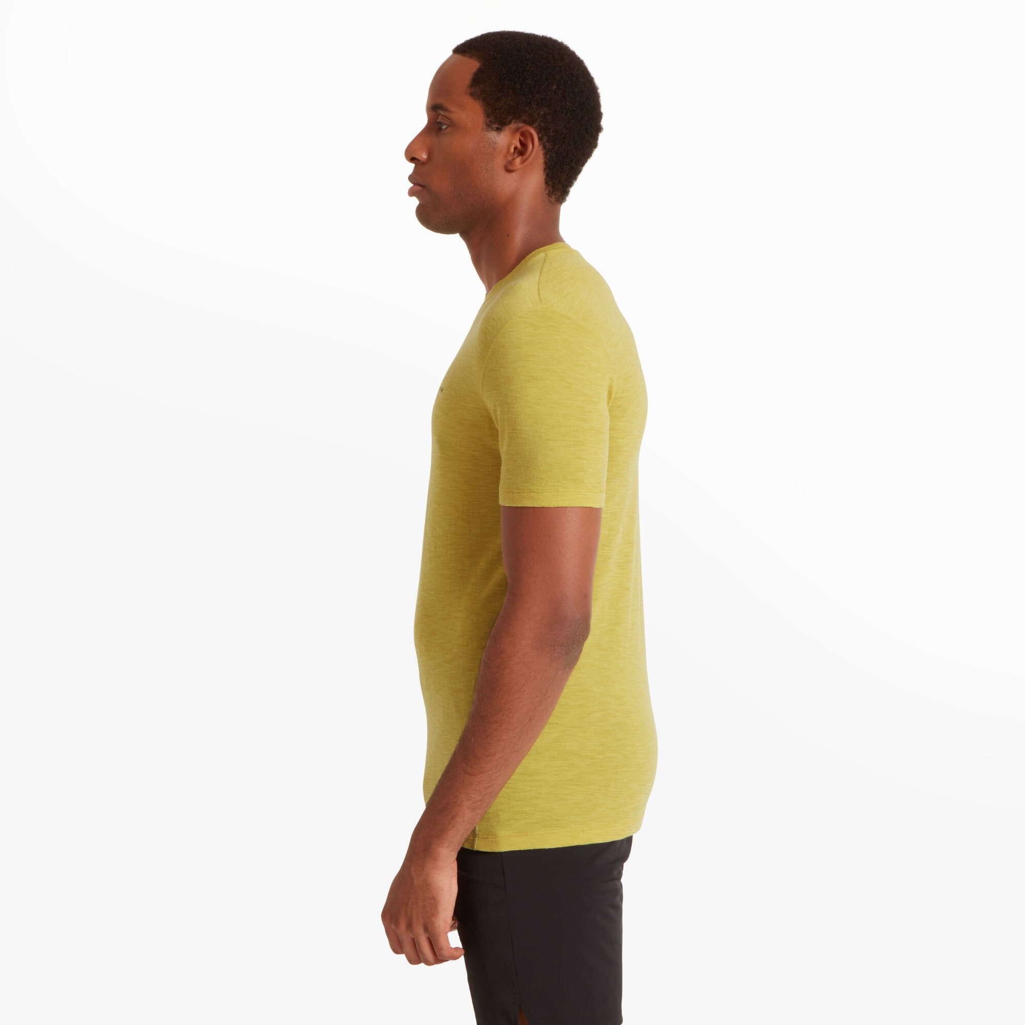 A profile shot of the male model wearing the same Artilect Performance Mens Sprint Tee Yellow. His arms are relaxed at his sides, and the shirt is slightly contoured to his torso. The lightweight, breathable fabric appears slightly textured. The sleeves fit snugly around his upper arms, and the hem falls just below his waist.