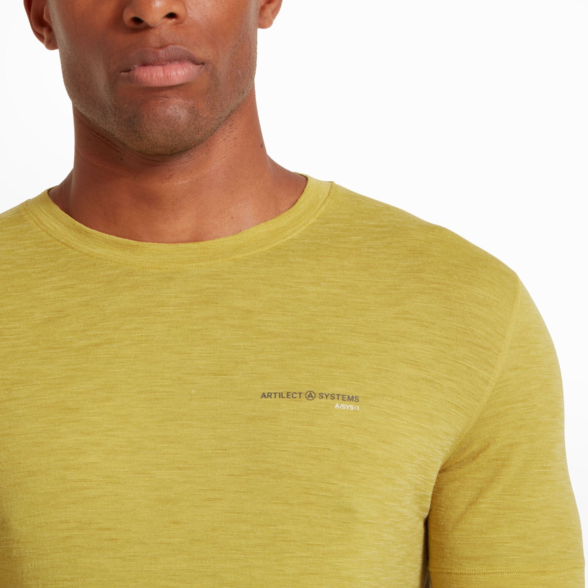A zoomed-in view of the upper portion of the Artilect Performance Mens Sprint Tee Yellow, focusing on the "ARTILECT SYSTEMS A/SYS-1" branding printed in a small, black font on the left side of the chest. The soft, moisture-wicking fabric has a heathered texture.