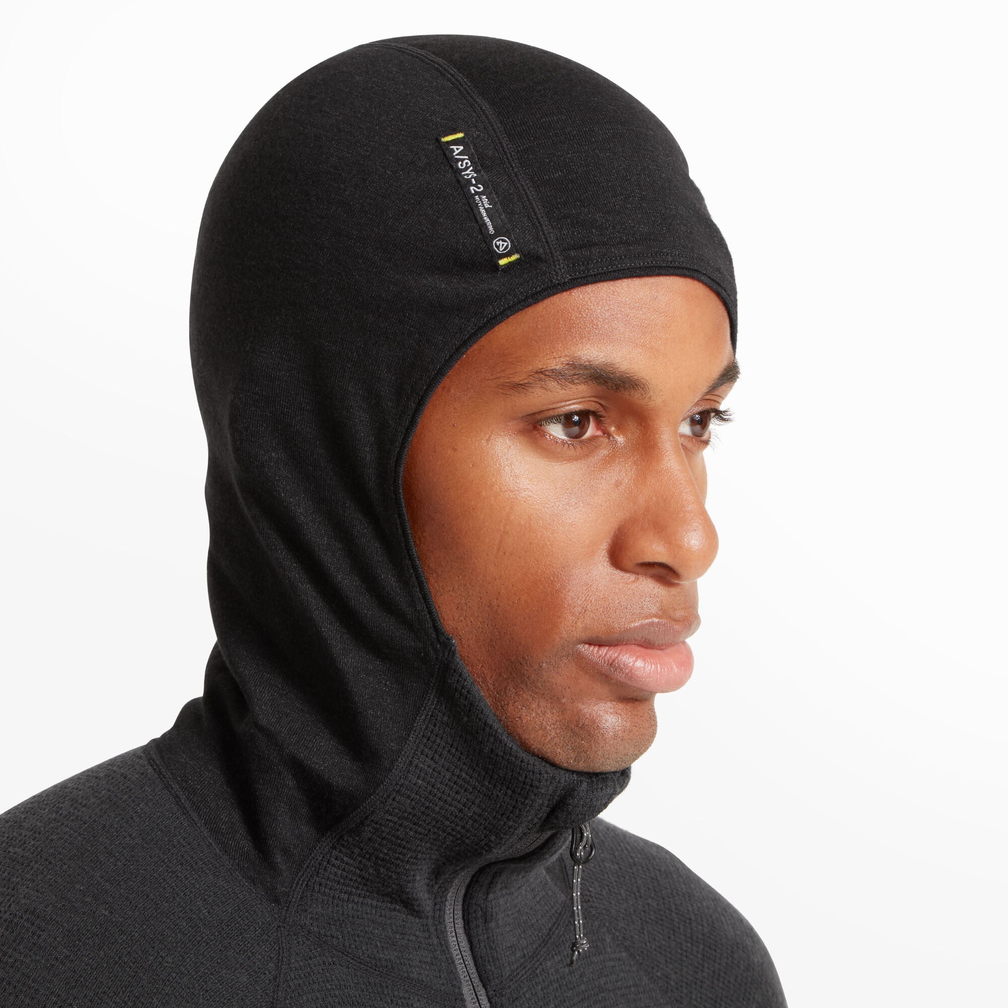Close-up of the man’s head wearing the Artilect Performance Mens Sundown 250 Half Zip Top Black fully zipped and hood pulled up, resembling a balaclava. A visible label on the side of the hood reads "Nuyarn A/SYS-2." The hood fits snugly around his head and neck, ideal for layering in cold weather.