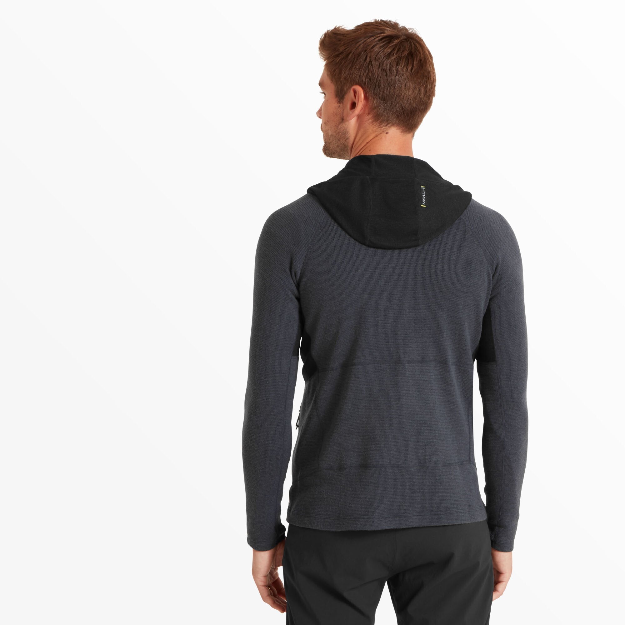 The man is shown from behind, revealing the fitted hood with a contrasting black panel and a small branded tag near the top on the Artilect Performance Mens Sundown 250 Half Zip Top Blue. The back hem falls slightly below the waist, and the fabric appears breathable and stretchy.