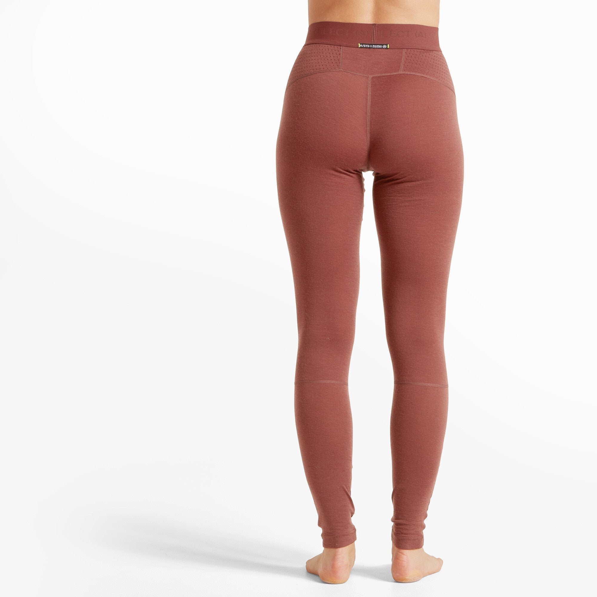 A rear view of the woman wearing the same Artilect Performance Womens Boulder 125 Legging Burgundy, highlighting the high-rise fit and perforated detailing around the waistband. There is a small branded tag on the back.