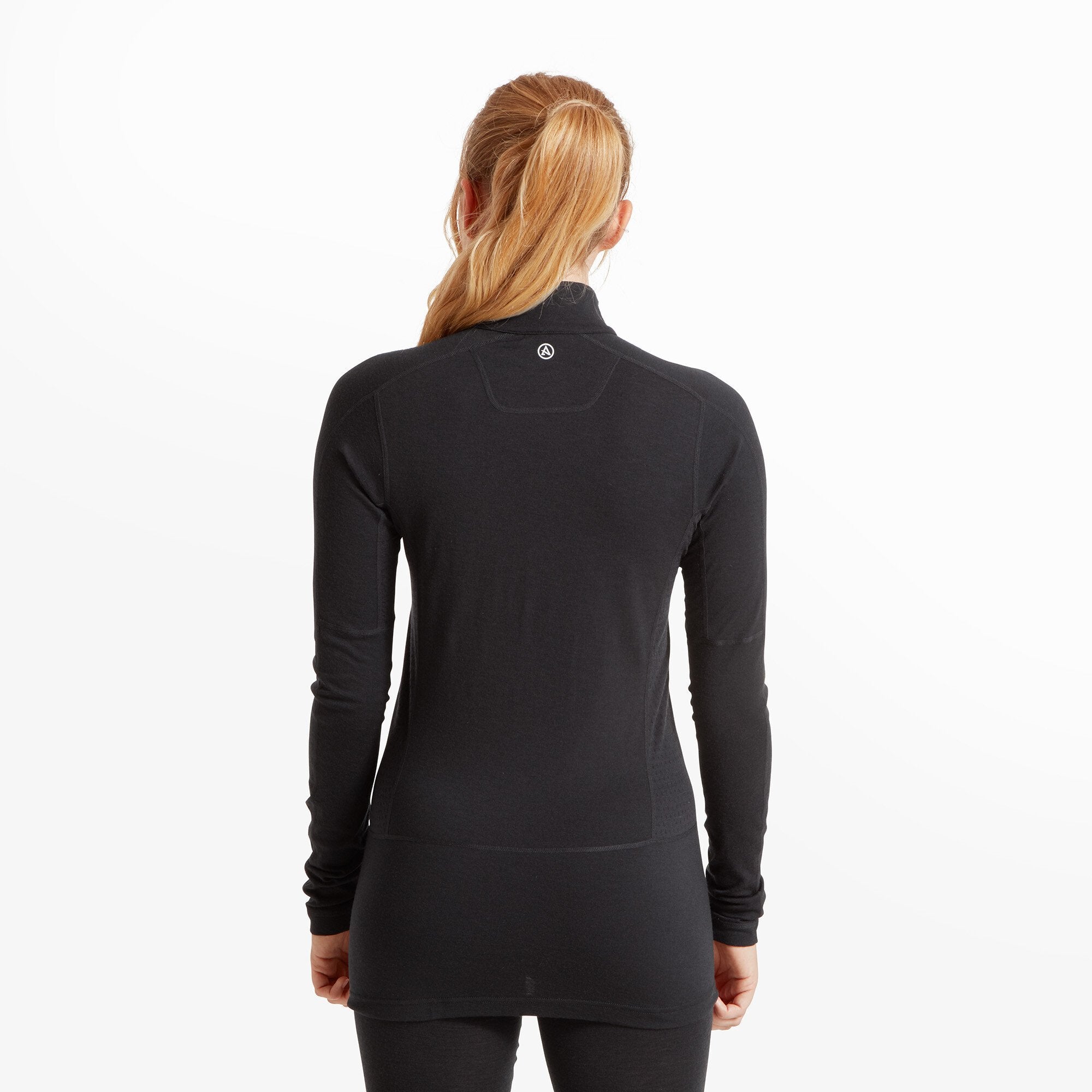 The model is seen from the back, highlighting the rear design of the Artilect Performance Womens Boulder 125 Quarter Zip Top Black. A small white logo is placed at the upper center, just below the collar. The seams contour the back for a streamlined fit. The model's blonde hair is loosely tied back, ensuring visibility of the garment’s design.
