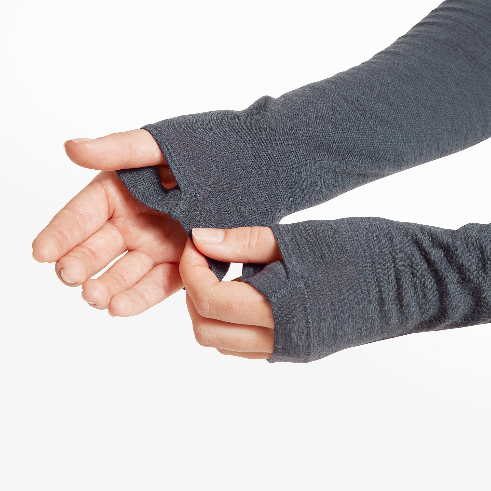 Close-up of the woman's hands pulling on the thumbhole cuffs of the sleeves on the Artilect Performance Womens Boulder 125 Quarter Zip Top Blue, showcasing the extended sleeve length and functionality designed to keep sleeves in place during movement.