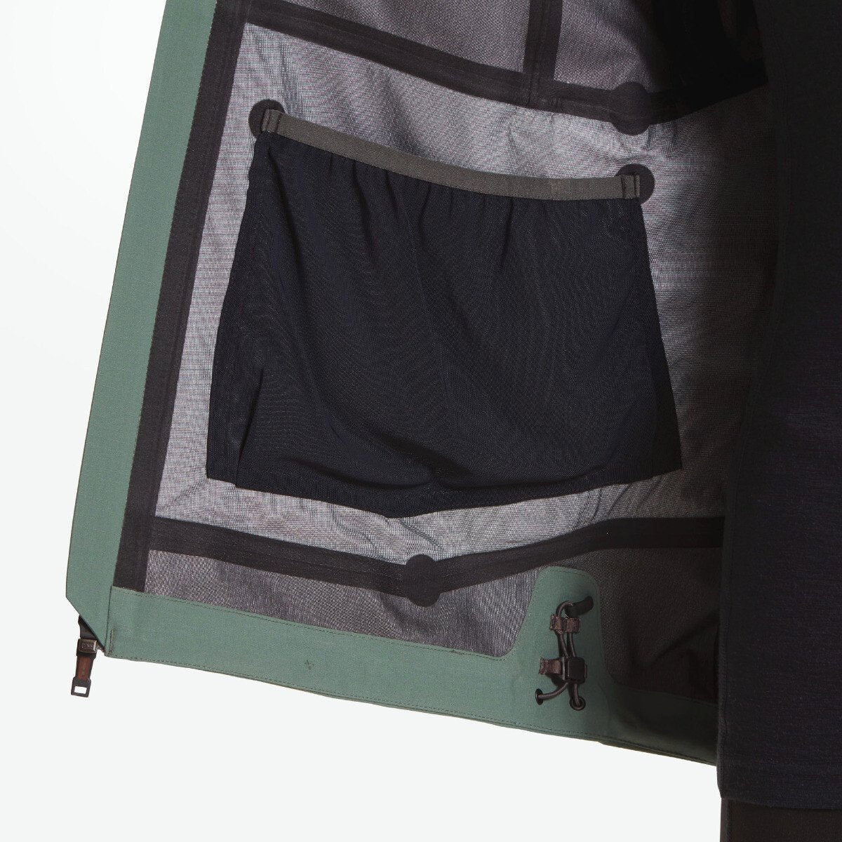 The inside of the Artilect Performance Womens Grandview 3L Jacket Green is displayed, revealing a large mesh storage pocket on the left panel and the seam-sealed, technical construction of the 3-layer shell fabric.