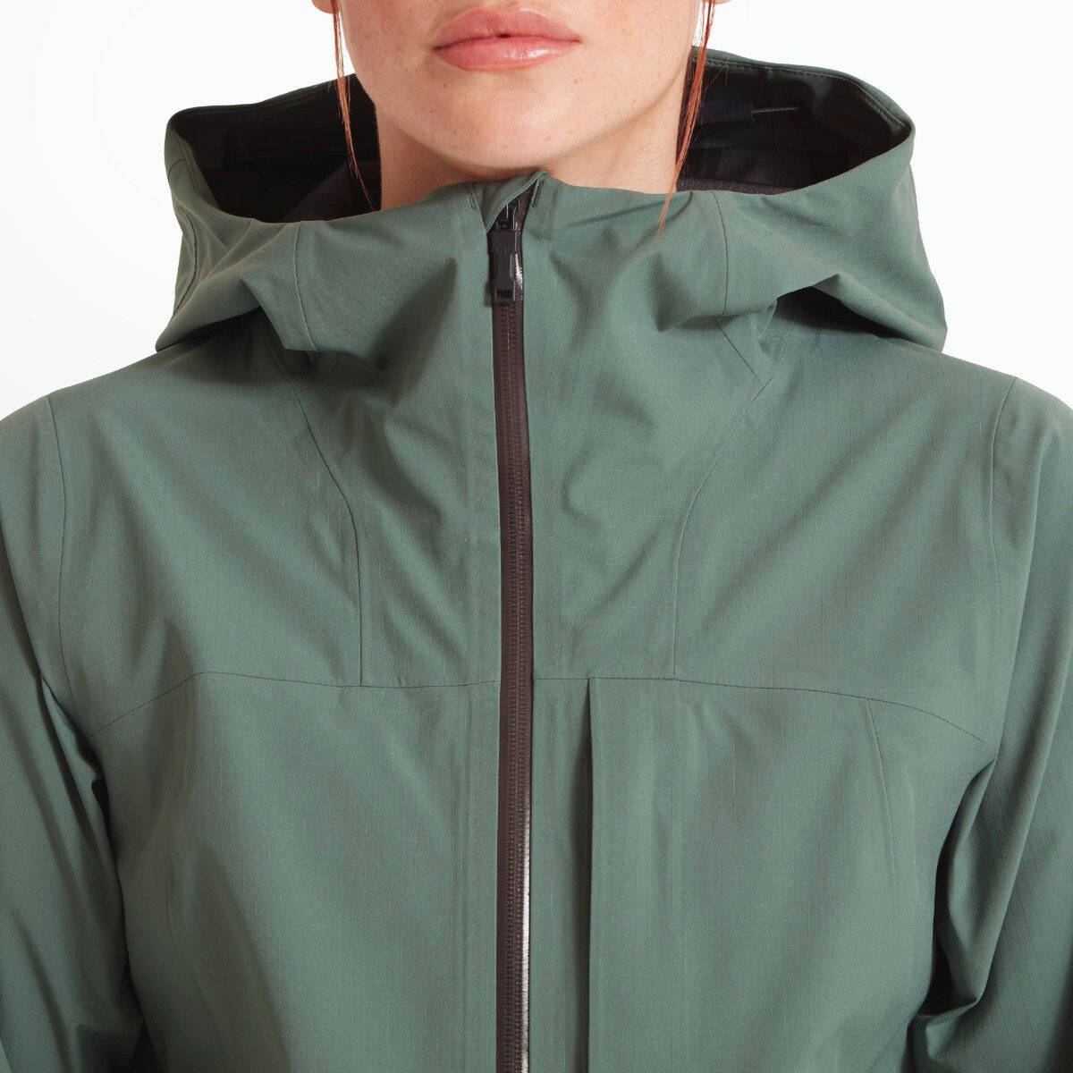 A cropped image highlighting the high collar zipped to the Artilect Performance Womens Grandview 3L Jacket Green. The hood fits snugly around the model’s neck, with panel seams providing a technical, performance-oriented look.