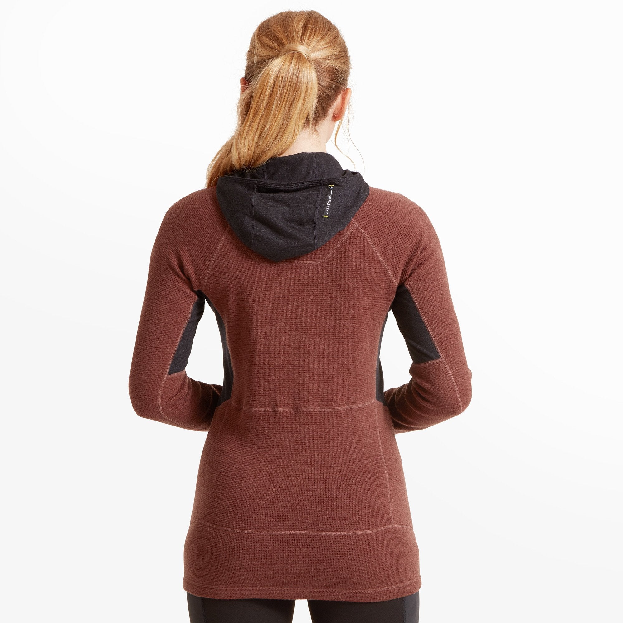 A close-up profile shot of the woman's head and shoulders, focused on the hood pulled up over her head on the Artilect Performance Womens Sundown 250 Half Zip Top Burgundy. The black hood fits snugly and displays the “ASYSS-2™ by Artilect” branding stitched on the upper side of the hood near the temple.