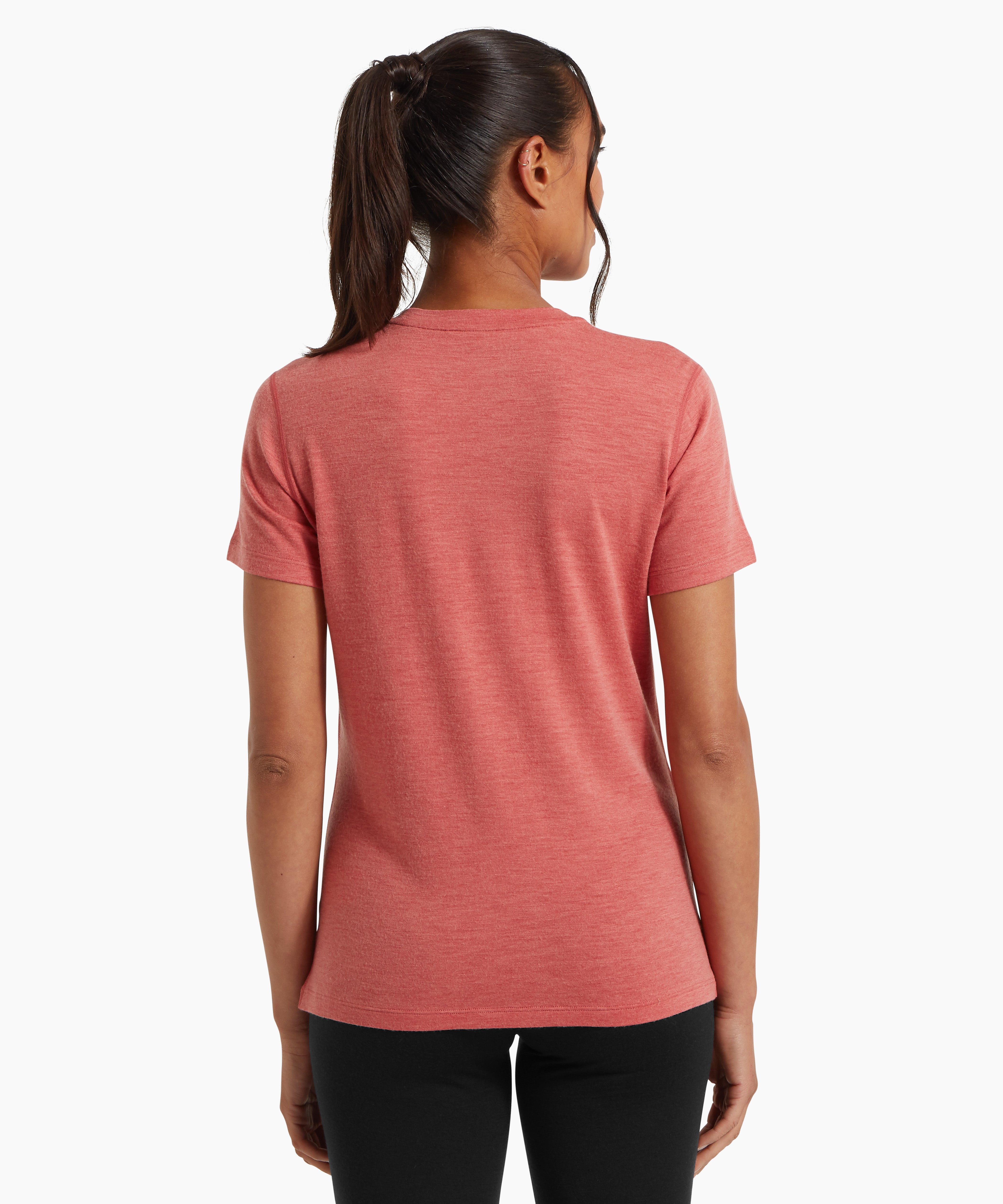 A woman wearing a fitted coral‑pink short‑sleeve T‑shirt and black leggings, shown from the back against a white background.